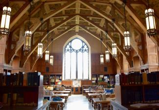 Large library and study space with arched ceiling and large gothic window