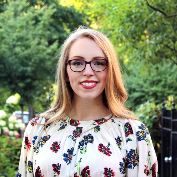 Portrait of Erica Warren standing outside in front of a garden and trees