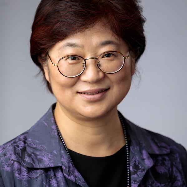 Portrait of Kyeong-Hee Choi standing in front of a grey background