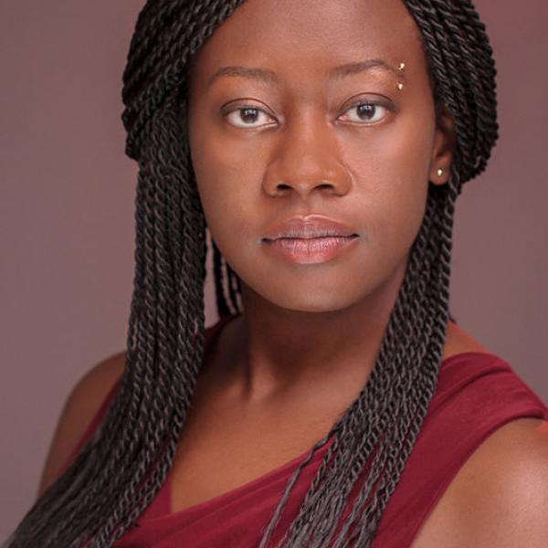 Portrait of Julie Iromuanya in front of a puce background
