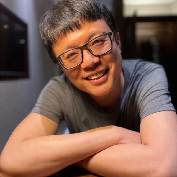 Portrait of Wei-Cheng Lin laughing with arms folded