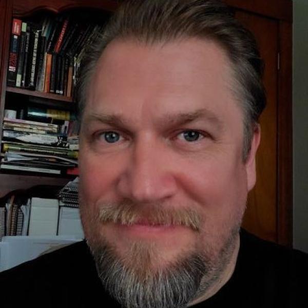 Portrait of Fred Kopp in front of a bookcase
