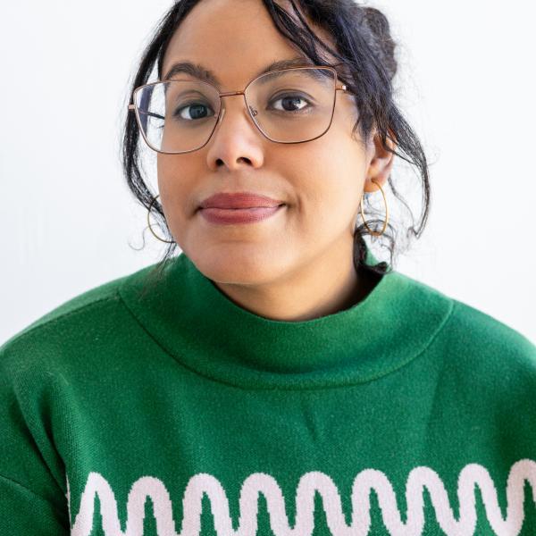 Portrait of Adrienne Brown in a green sweater against a white background
