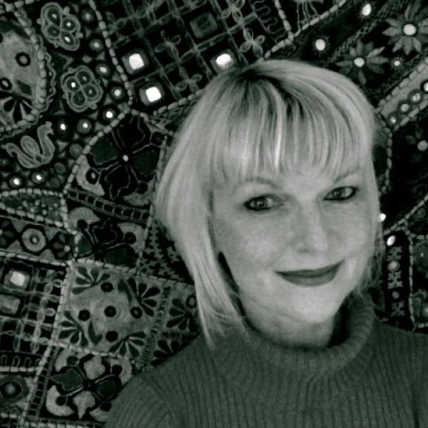 Black and white portrait of Ulrike Stark standing in front of a patterned background