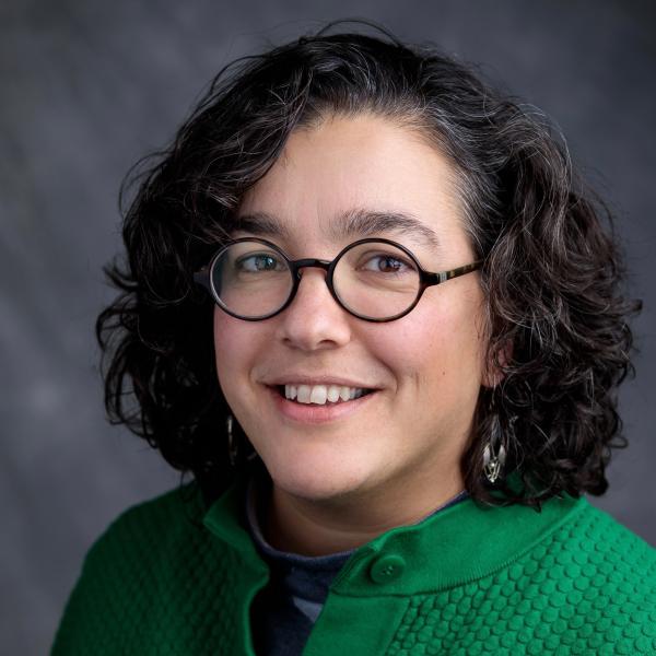 Portrait of Na'ama Rokem shoulders up in front of a grey backdrop